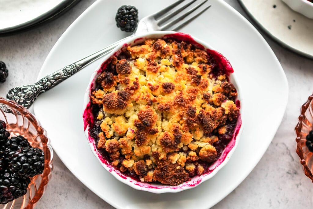 Keto blackberry crumble with brightly colored blackberry filling.