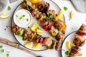 Skewers of Mediterranean kabobs with chicken thighs, bell pepper, onion and whipped feta dip.