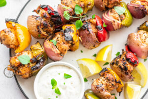 Skewers of Mediterranean chicken kabobs with bell pepper, onion and whipped feta dip.