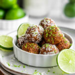Dish filled with key lime pie energy balls covered in coconut and lime zest.