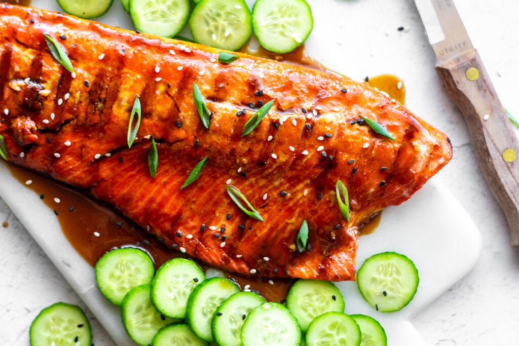 Salmon filets covered with paleo teriyaki sauce, sesame seeds and green onions.