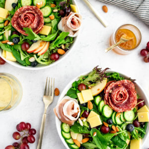 Charcuterie salad with nuts, salami, cheese, grapes, blueberries, olives and cucumbers.