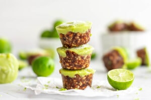 Stack of bright green mini paleo vegan key lime tarts.