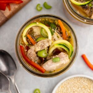 Jar of low carb instant noodles made with zoodles, chicken thighs and colorful veggies.