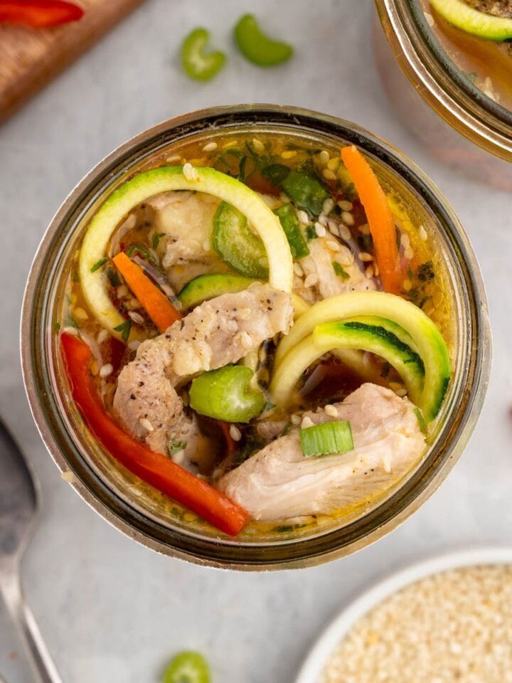 Jar of low carb instant noodles made with zoodles, chicken thighs and colorful veggies.