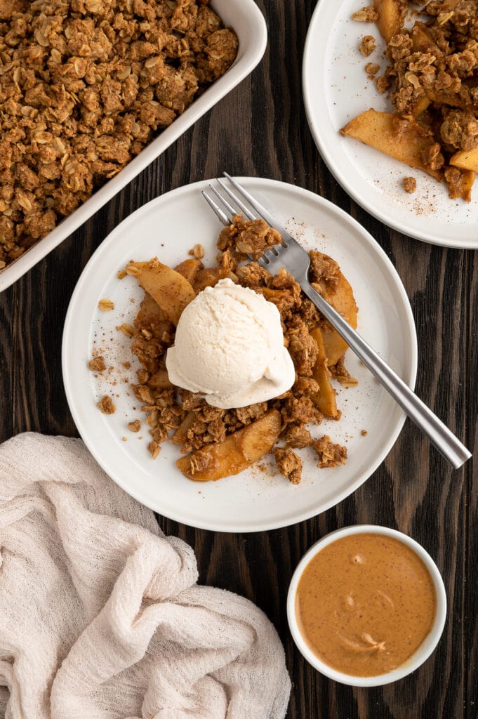 Plate of gluten-free Peanut butter apple crisp topped with ice cream.