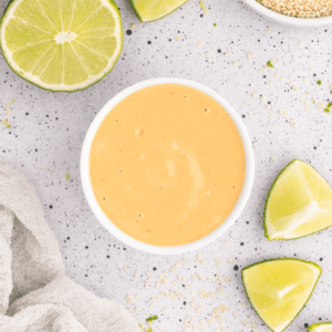 Bowl of orange colored spicy tahini sauce.