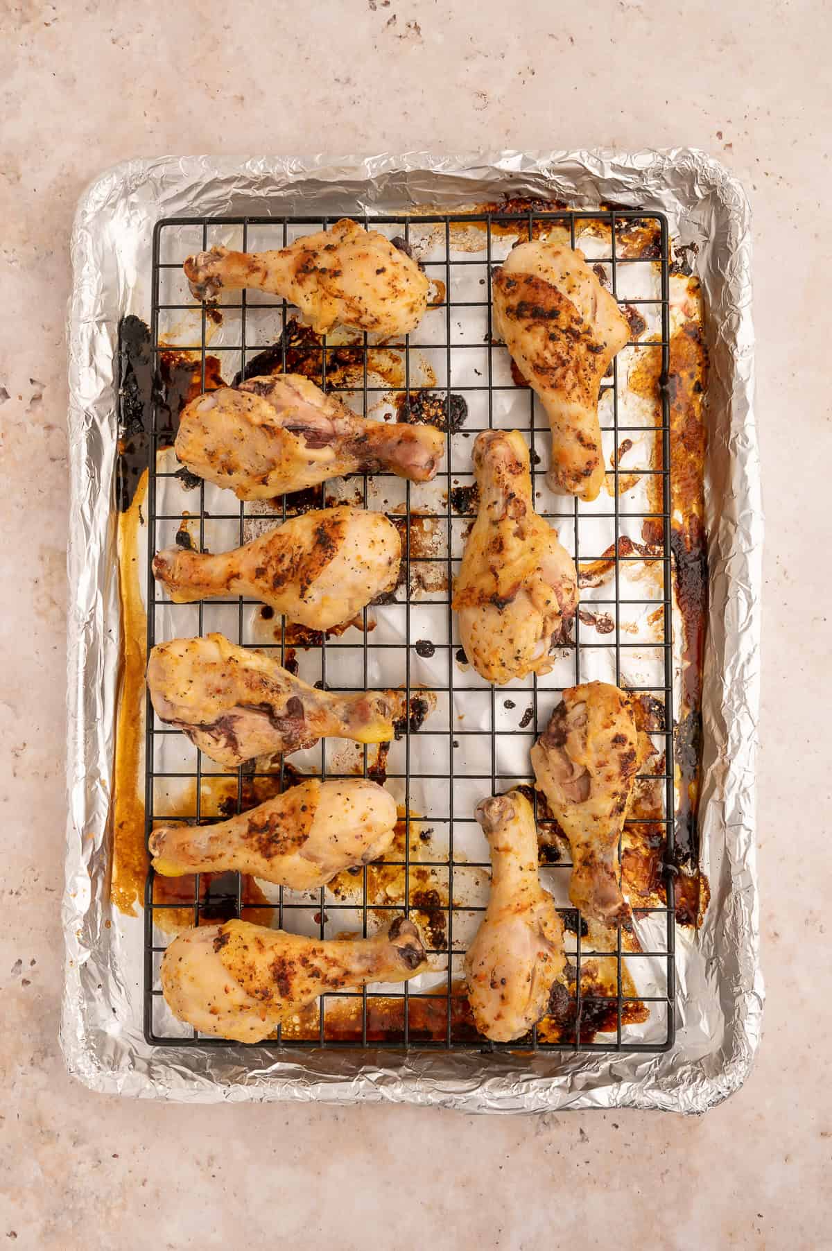Baked chicken drumsticks on a sheet pan.