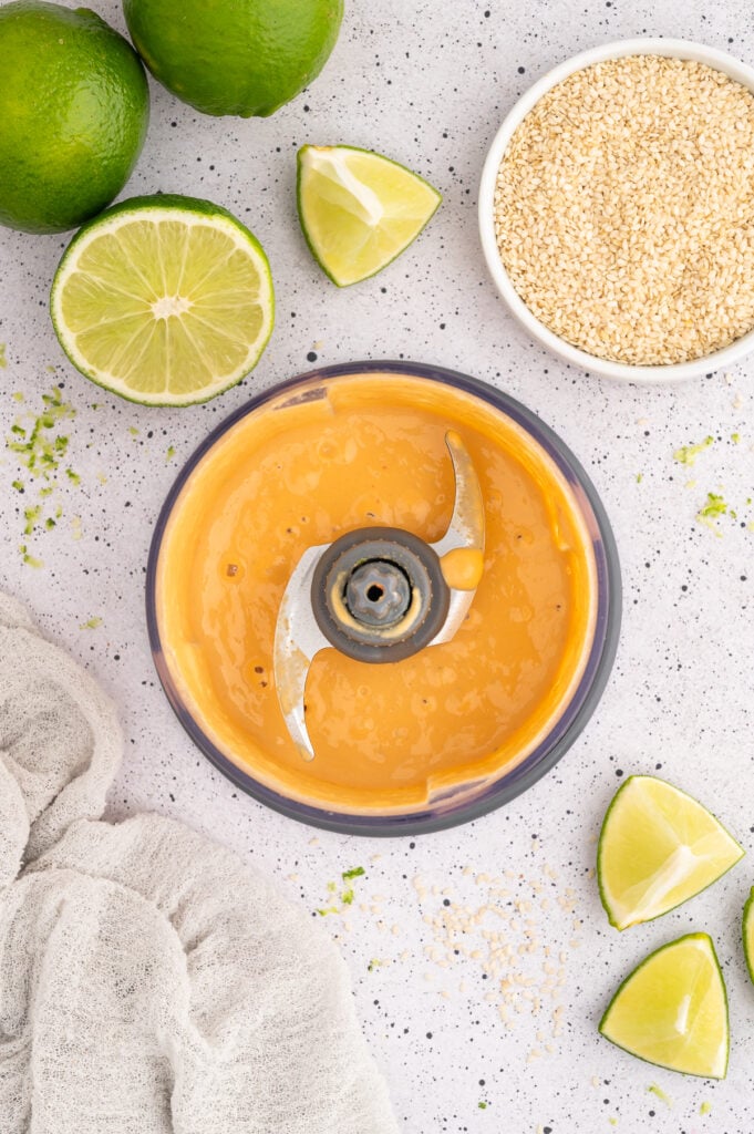 Food processor blending spicy tahini sauce.