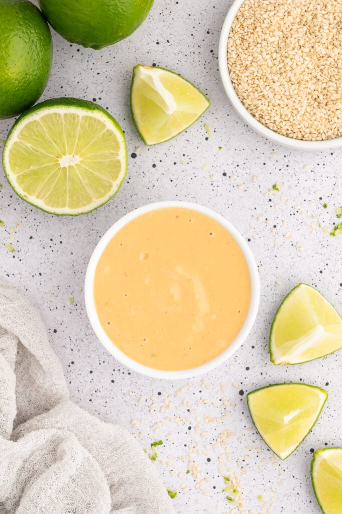 Bowl of orange colored spicy tahini sauce.