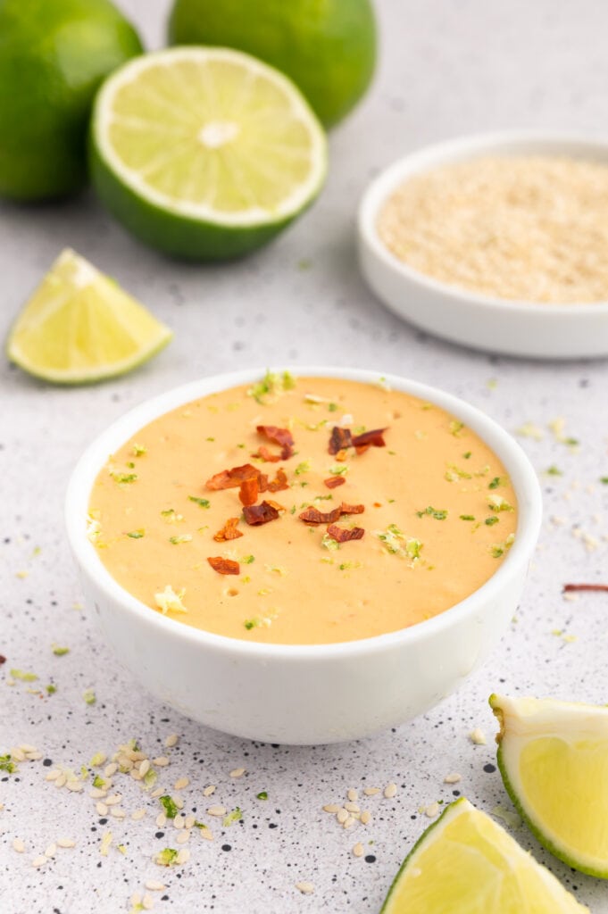 Bowl of orange colored spicy tahini sauce.