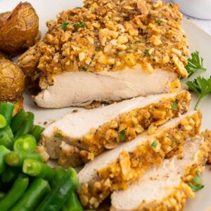 Almond crusted chicken plated with potatoes and green beans.