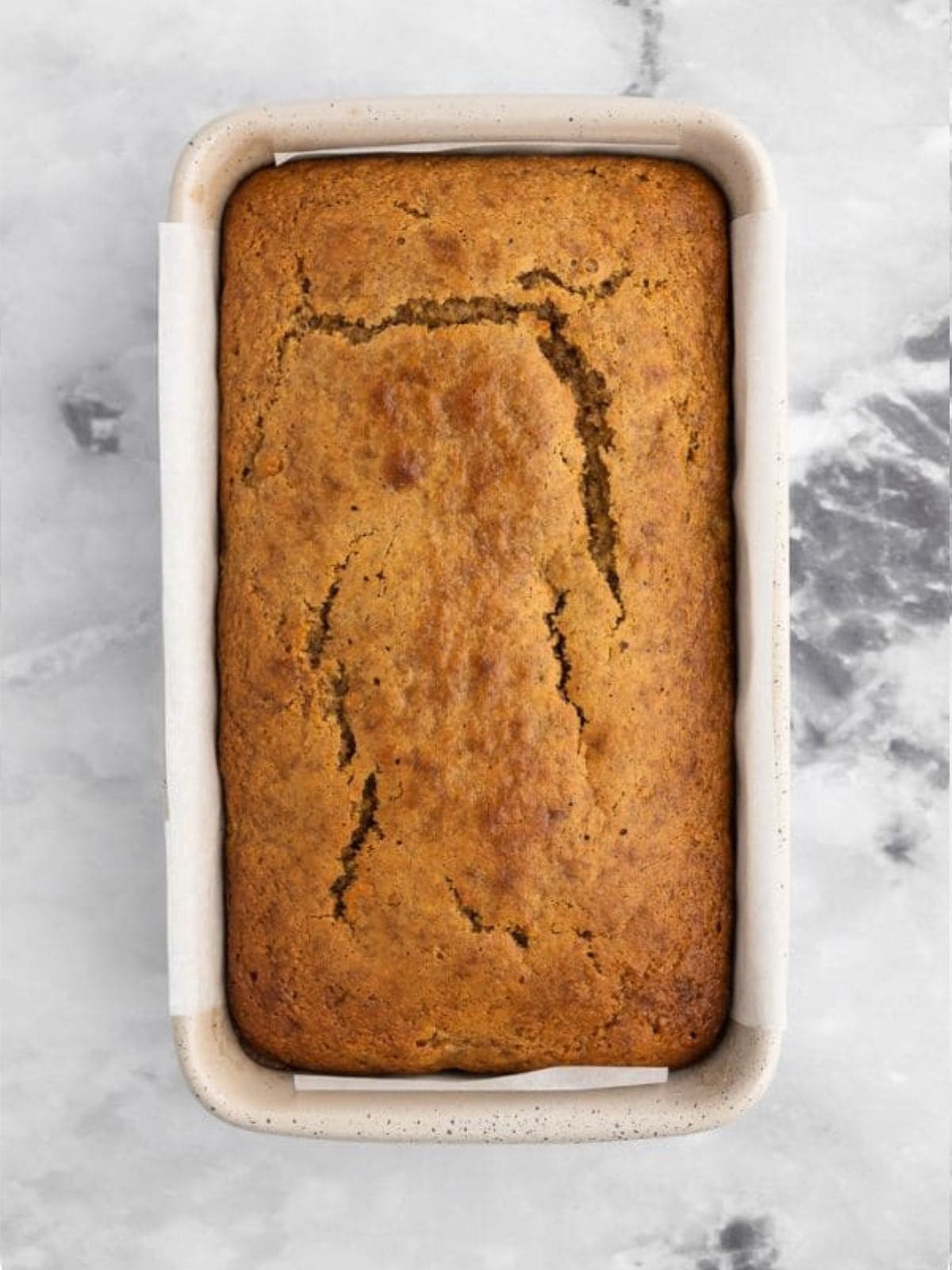 Baked loaf of paleo almond butter banana bread in bread pan.