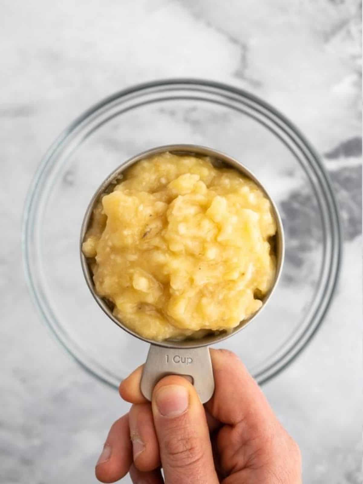 Measuring mashed bananas for almond butter banana bread.