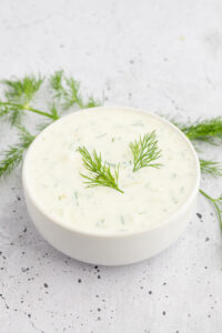 Bowl of Tzatziki Sauce topped with fresh dill.