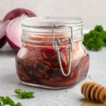 Jar containing balsamic pickled onions.