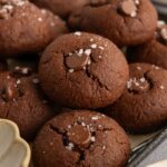 Pile of almond flour cocoa cookies with sea salt on top.