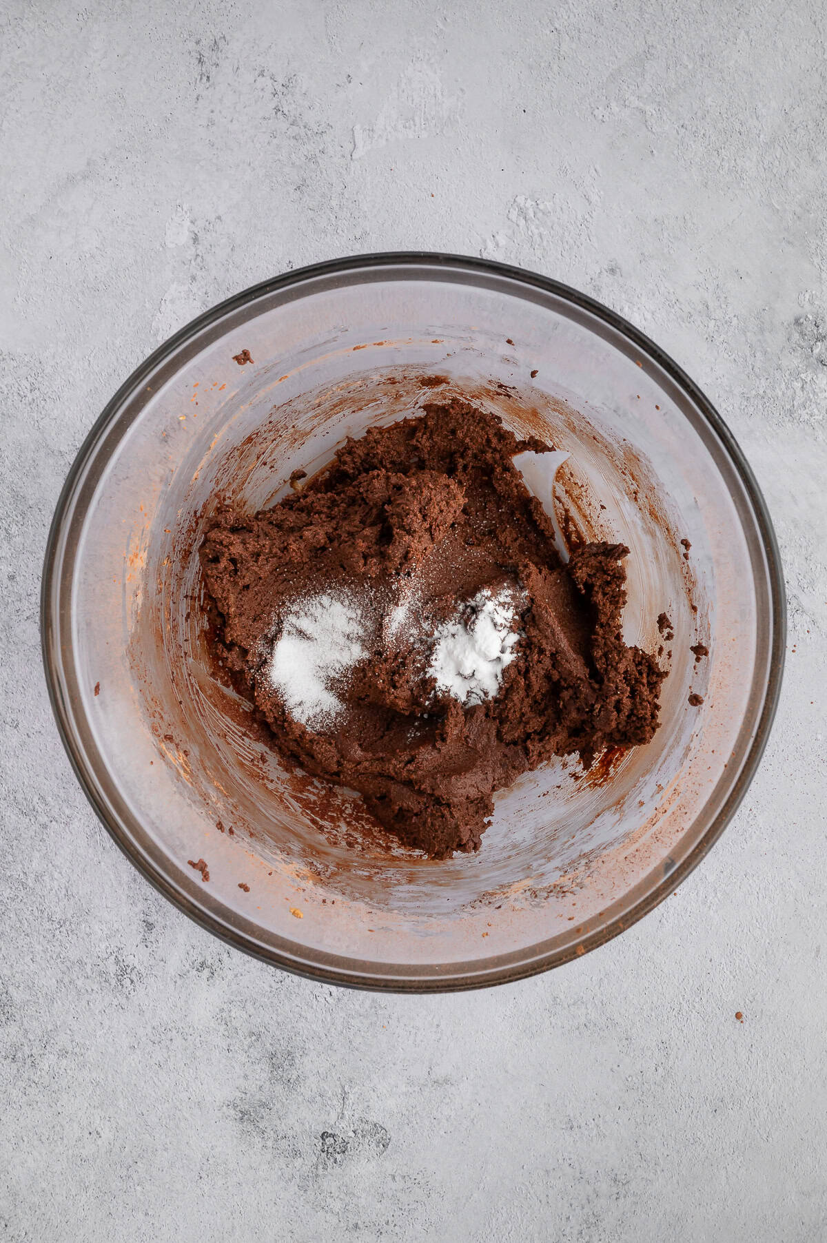 Adding leavening agents to dough in mixing bowl.
