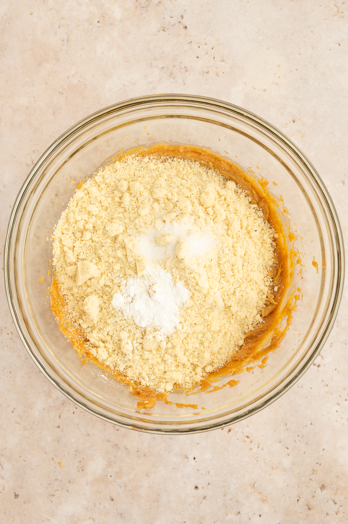 Dry ingredients added to wet ingredients for almond flour peanut butter cookies in a mixing bowl.