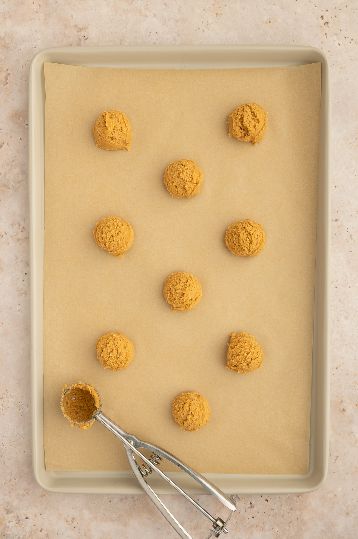 Cookies scooped out onto parchment paper lined baking sheet.