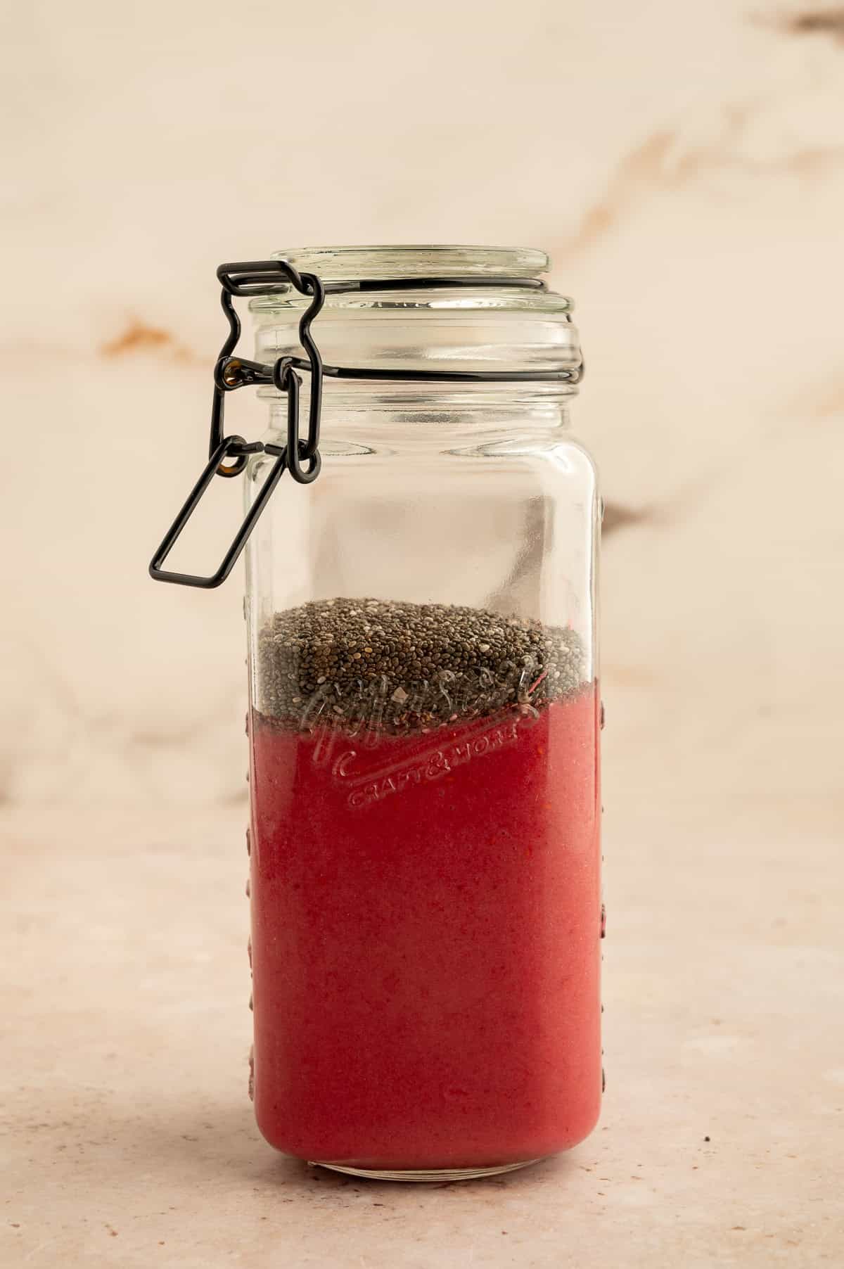 Chia seeds and berry mixture added to a jar.
