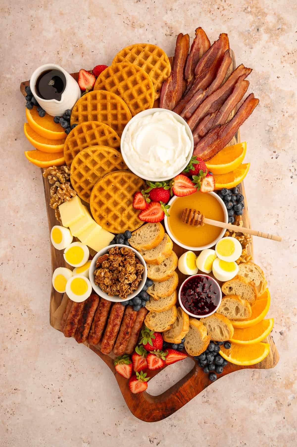 Filling the holes in the charcuterie board with smaller items like berries and nuts.