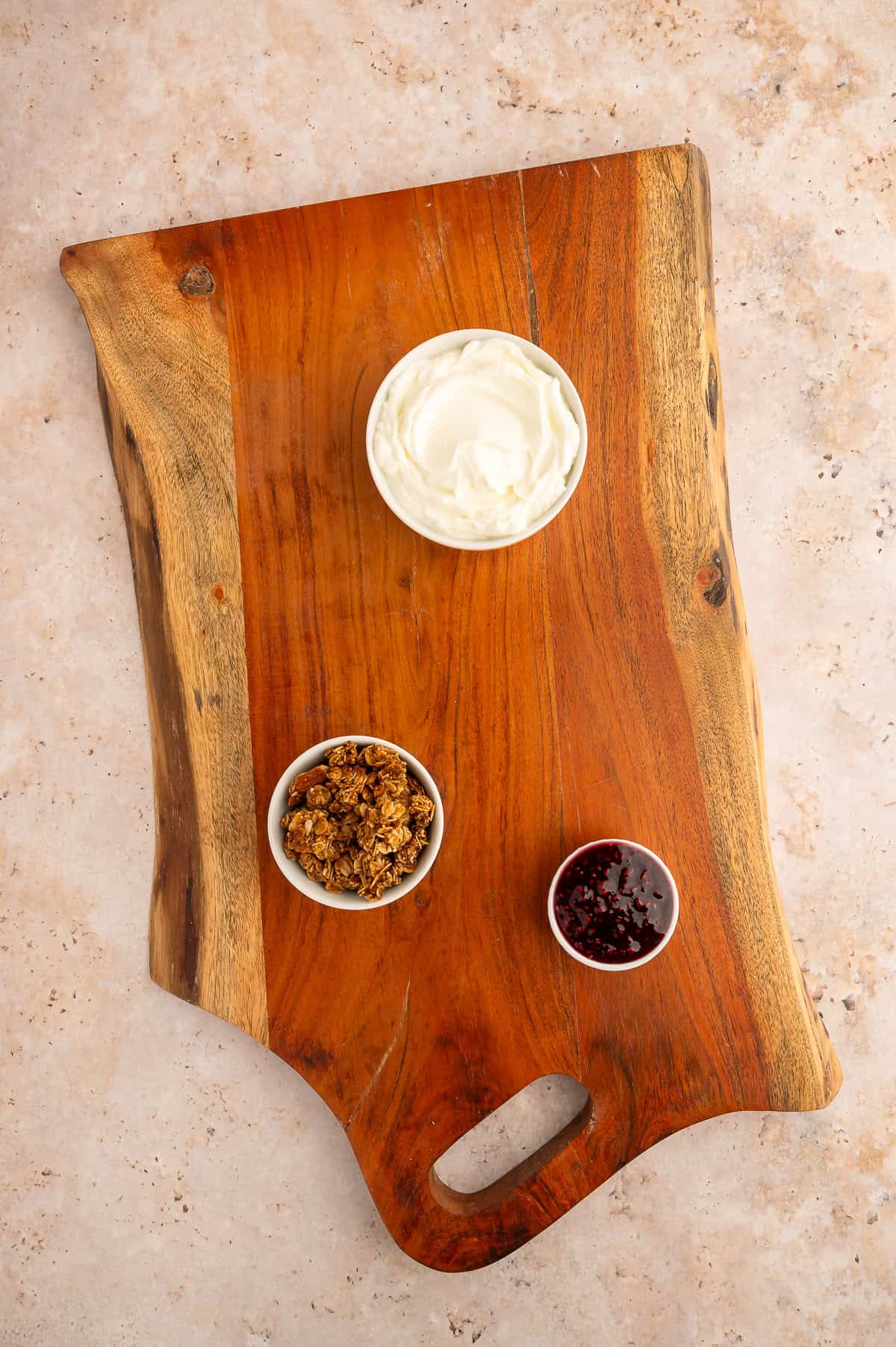 Placing initial ramekins on board for brunch charcuterie board.