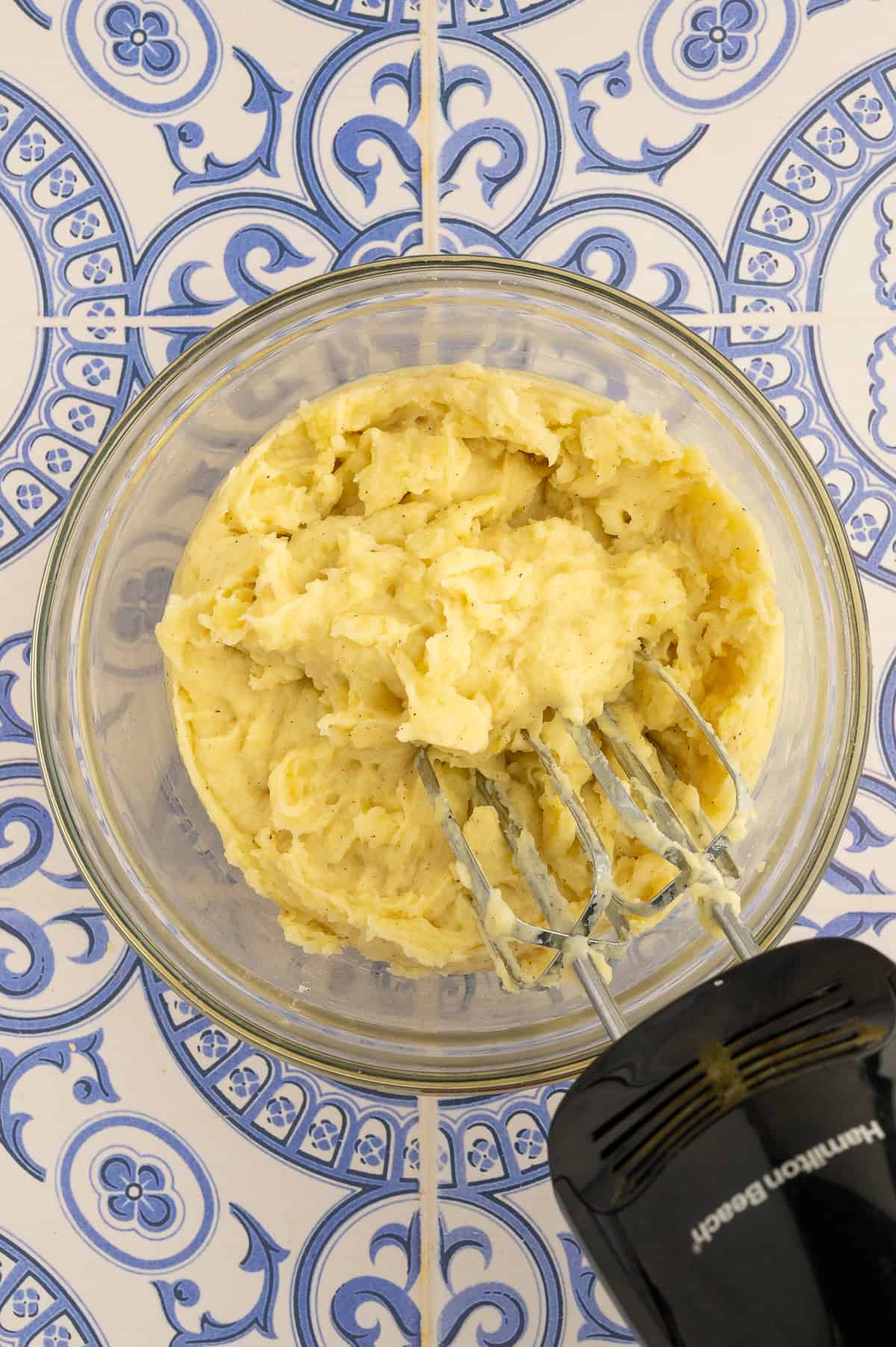 Mashing potatoes with electric mixer.