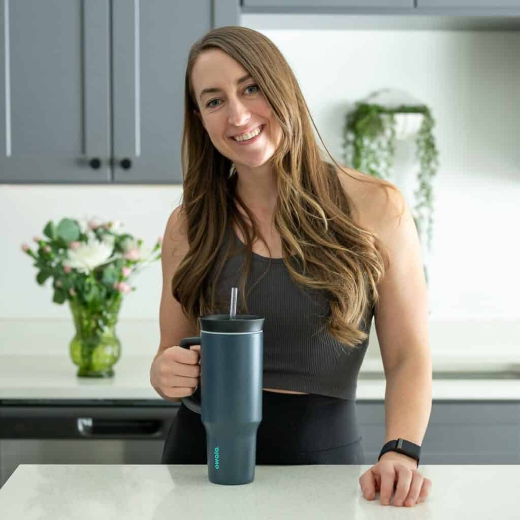 Amanda in a kitchen with a water bottle.