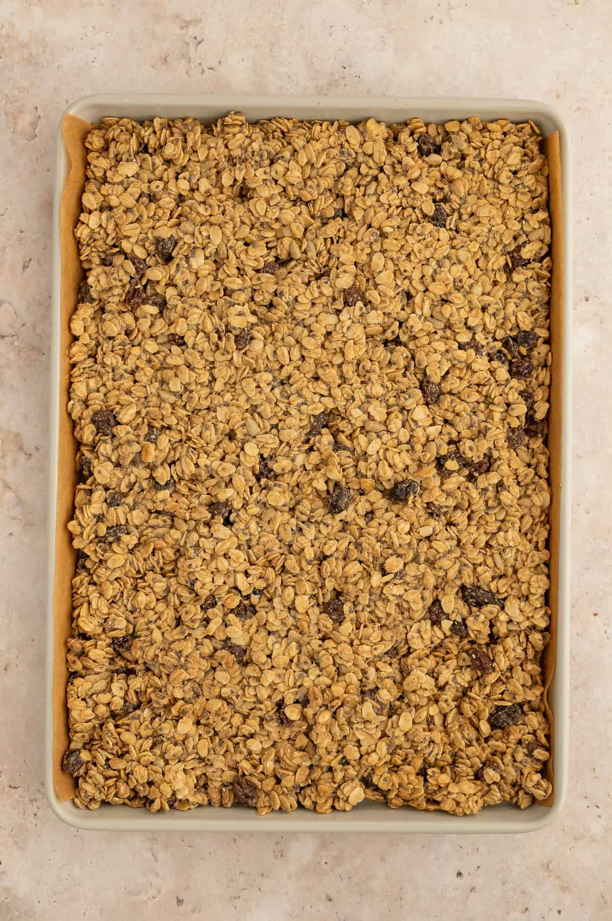 Baked granola on a sheet pan, not broken up yet.