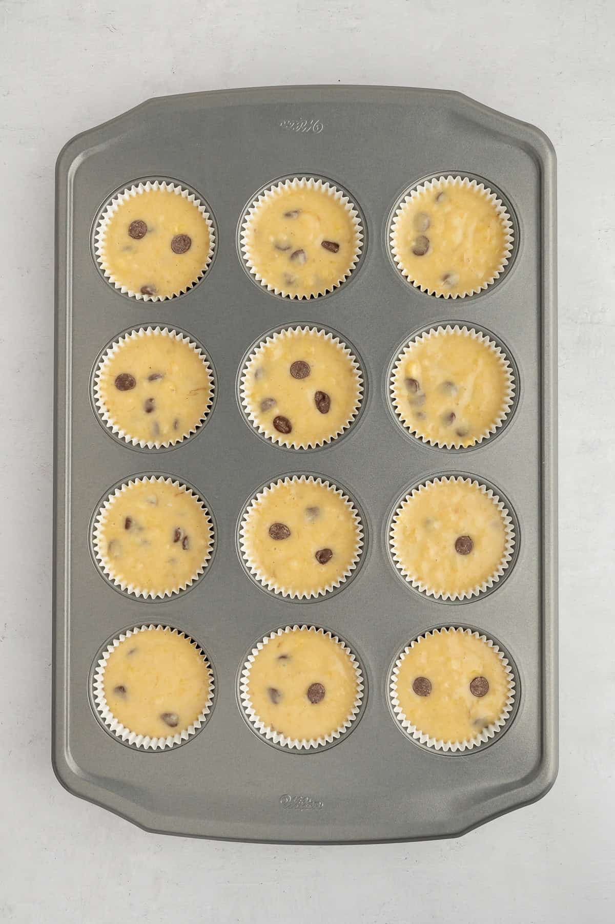 Muffin batter in lined muffin tin.