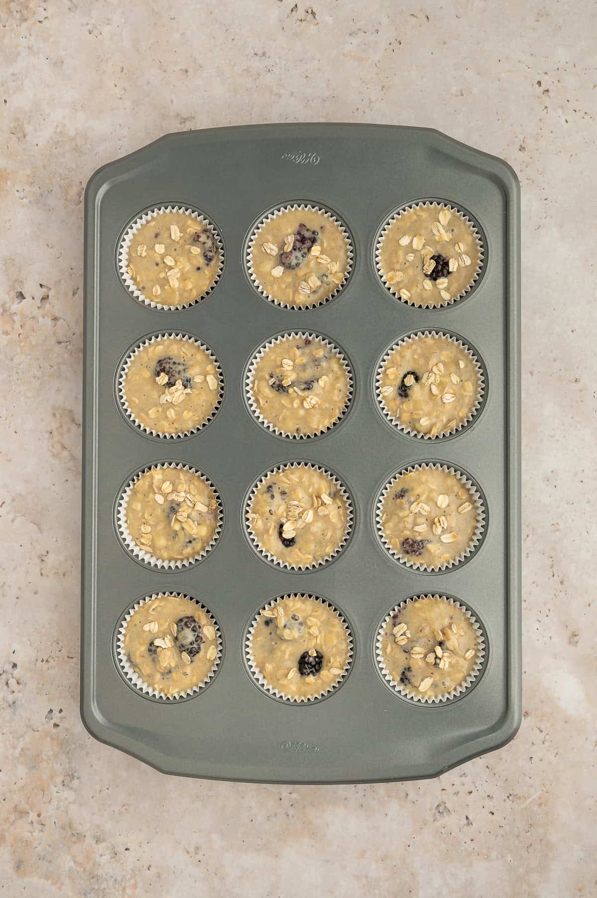 Batter for banana blackberry oatmeal muffins in a muffin tin.