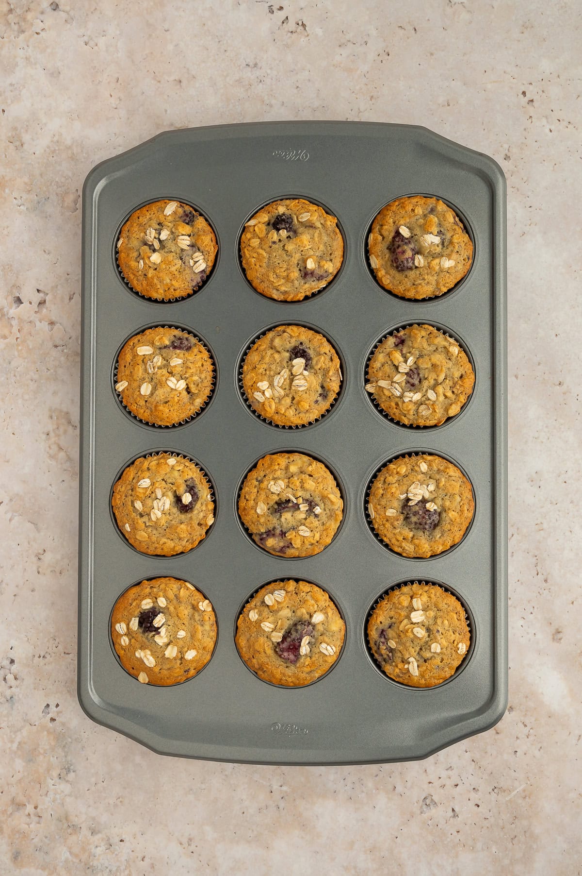 Baked banana blackberry oatmeal muffins in a muffin tin.