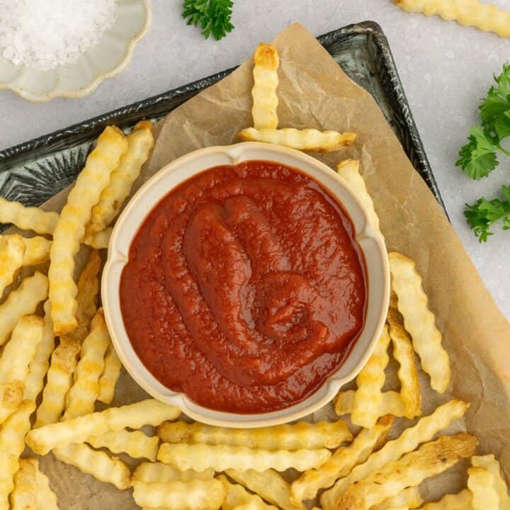Homemade no sugar tomato ketchup on a platter of fries.