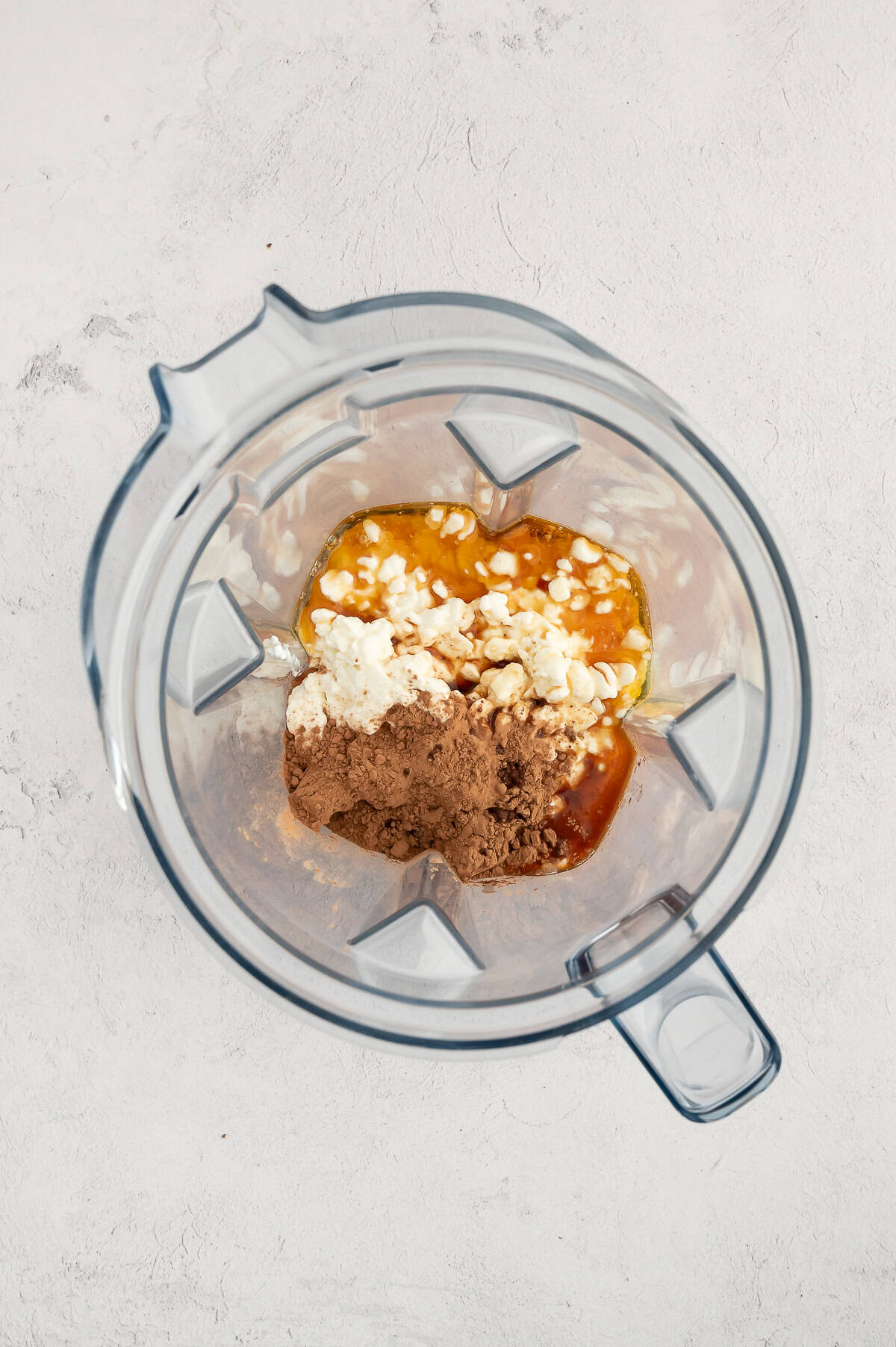 Cottage cheese, maple syrup, cocoa powder and vanilla in blender.