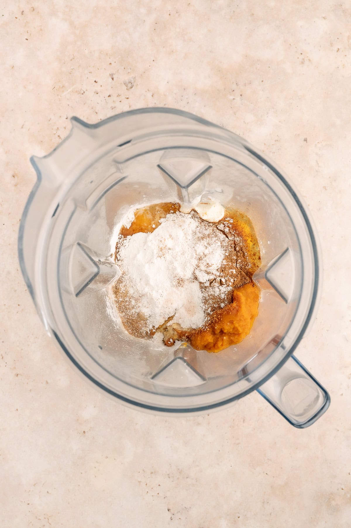 Blender with ingredients for protein pumpkin cheesecake.