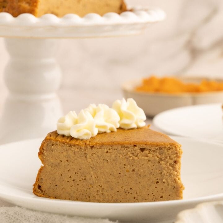 Slice of protein pumpkin cheesecake with whipped cream on top.