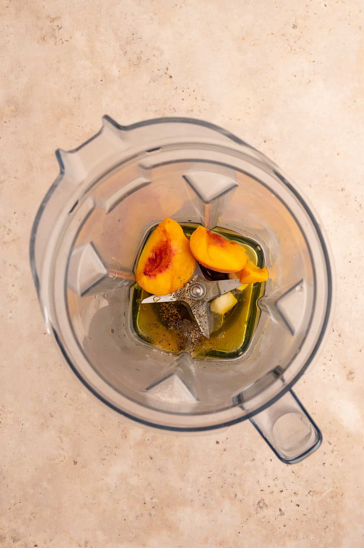 Ingredients for peach salad dressing in a blender pitcher.