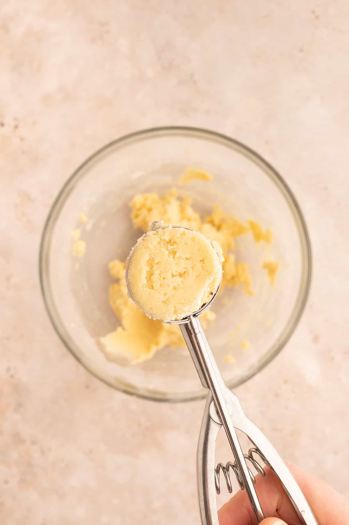 Scooping dough out using a 1-ounce cookie scoop.