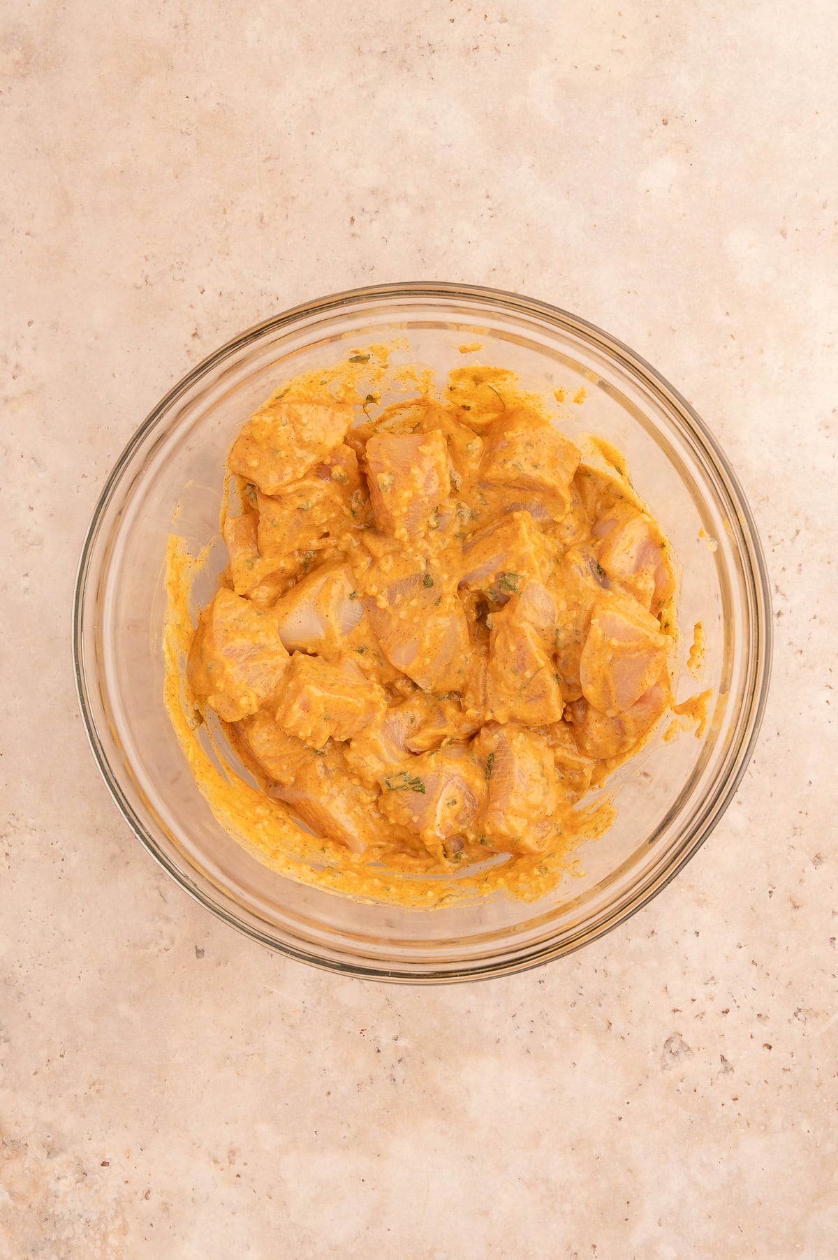 Chicken marinading in large mixing bowl.