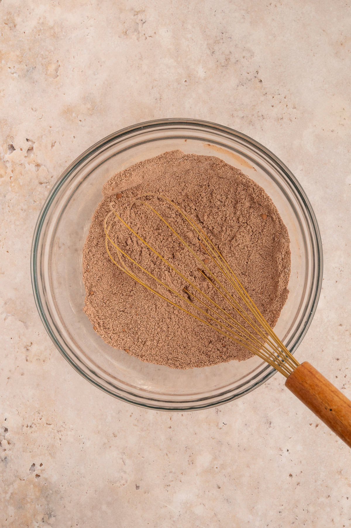Dry ingredients for almond flour chocolate cupcakes whisked together in a mixing bowl.