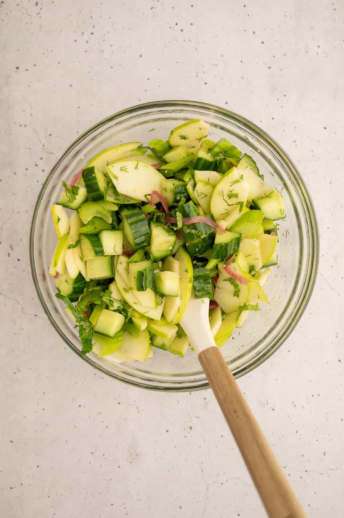 Salad mixed together in a mixing bowl.